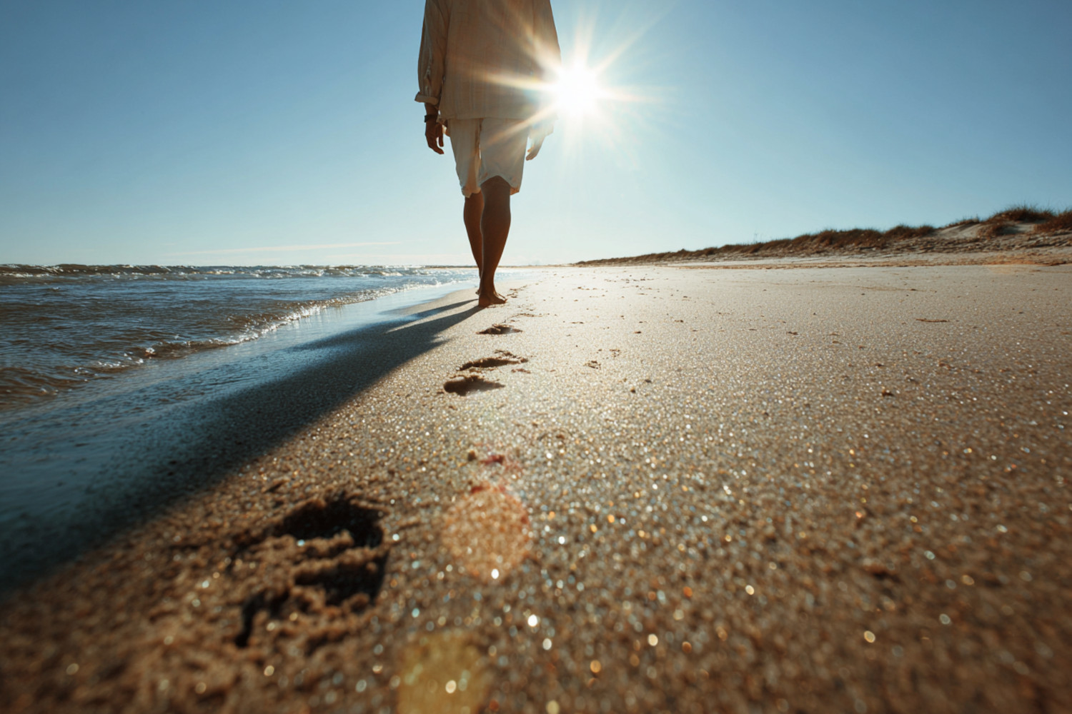 Eine Person geht allein am Strand entlang