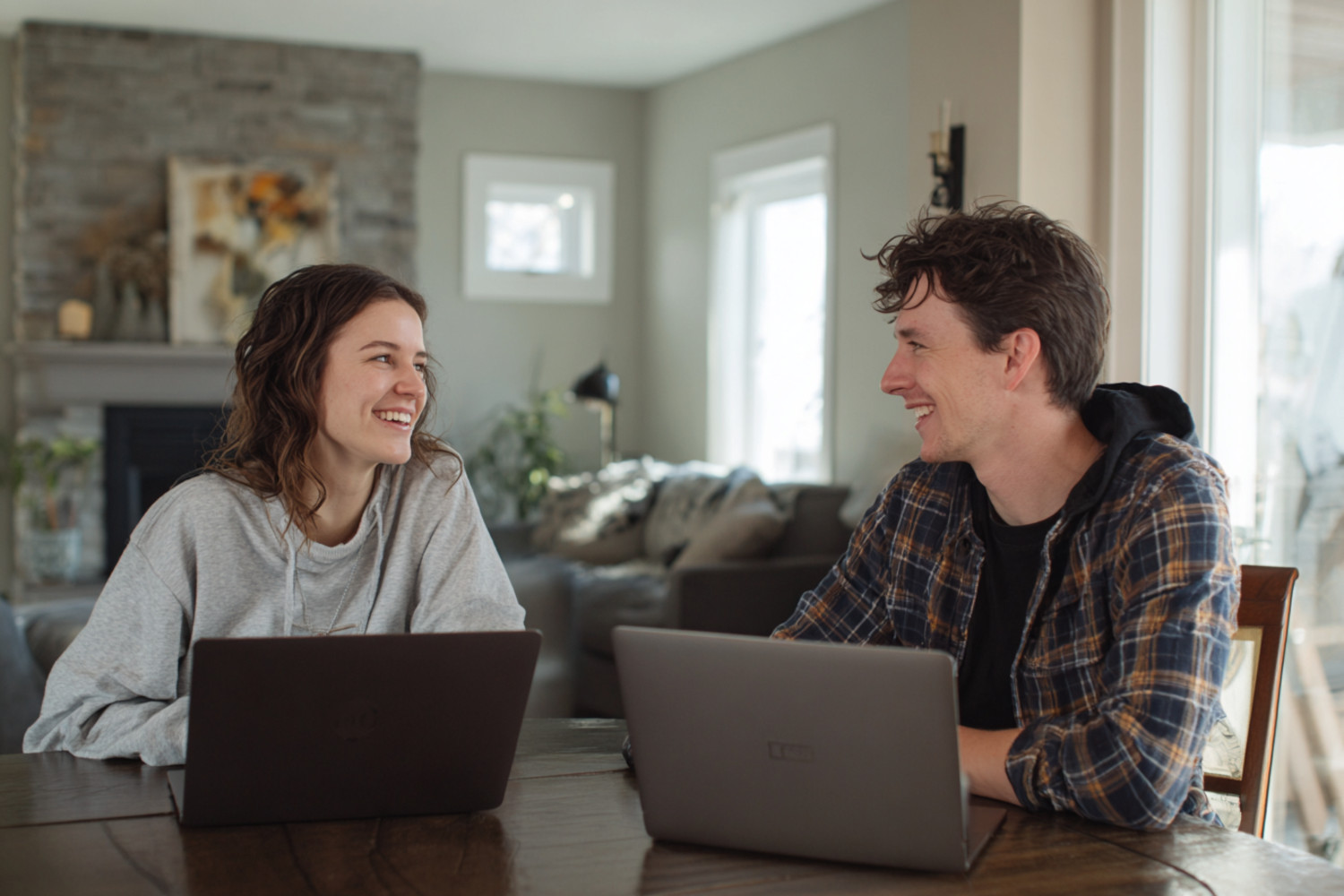 Ein Mann und eine Frau sitzen zu Hause am Tisch und arbeiten an Laptops