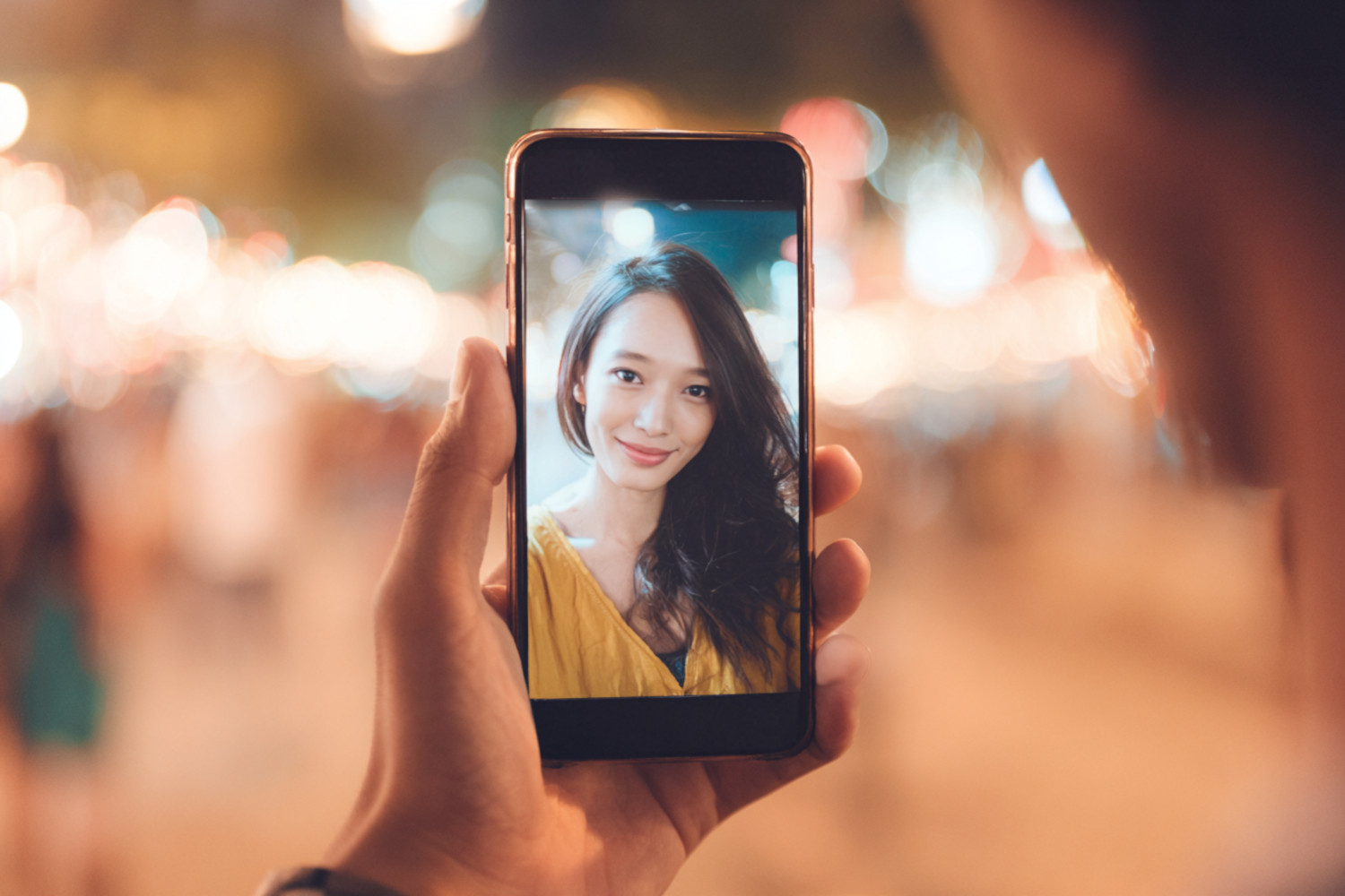 Smartphone mit einer lächelnden Frau darauf