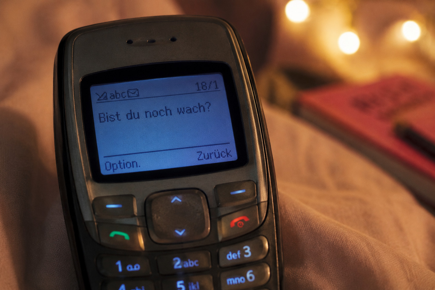 Ein altes Tastenhandy, im Bildschirm steht 