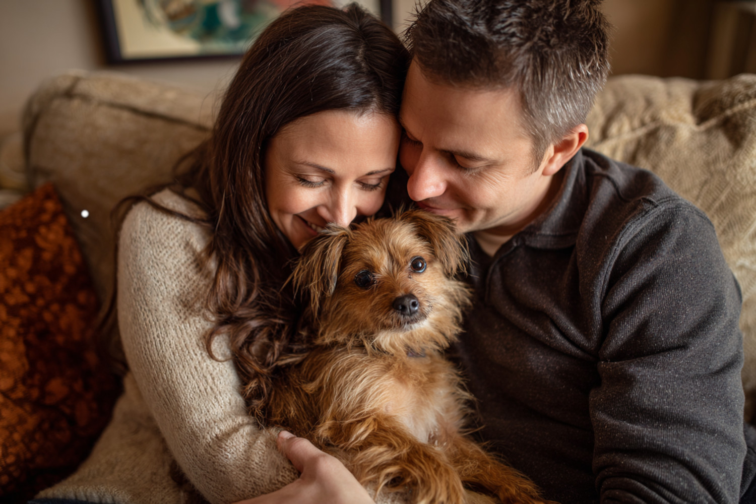 Ein Mann und eine Frau kuscheln mit einem kleinen Hund