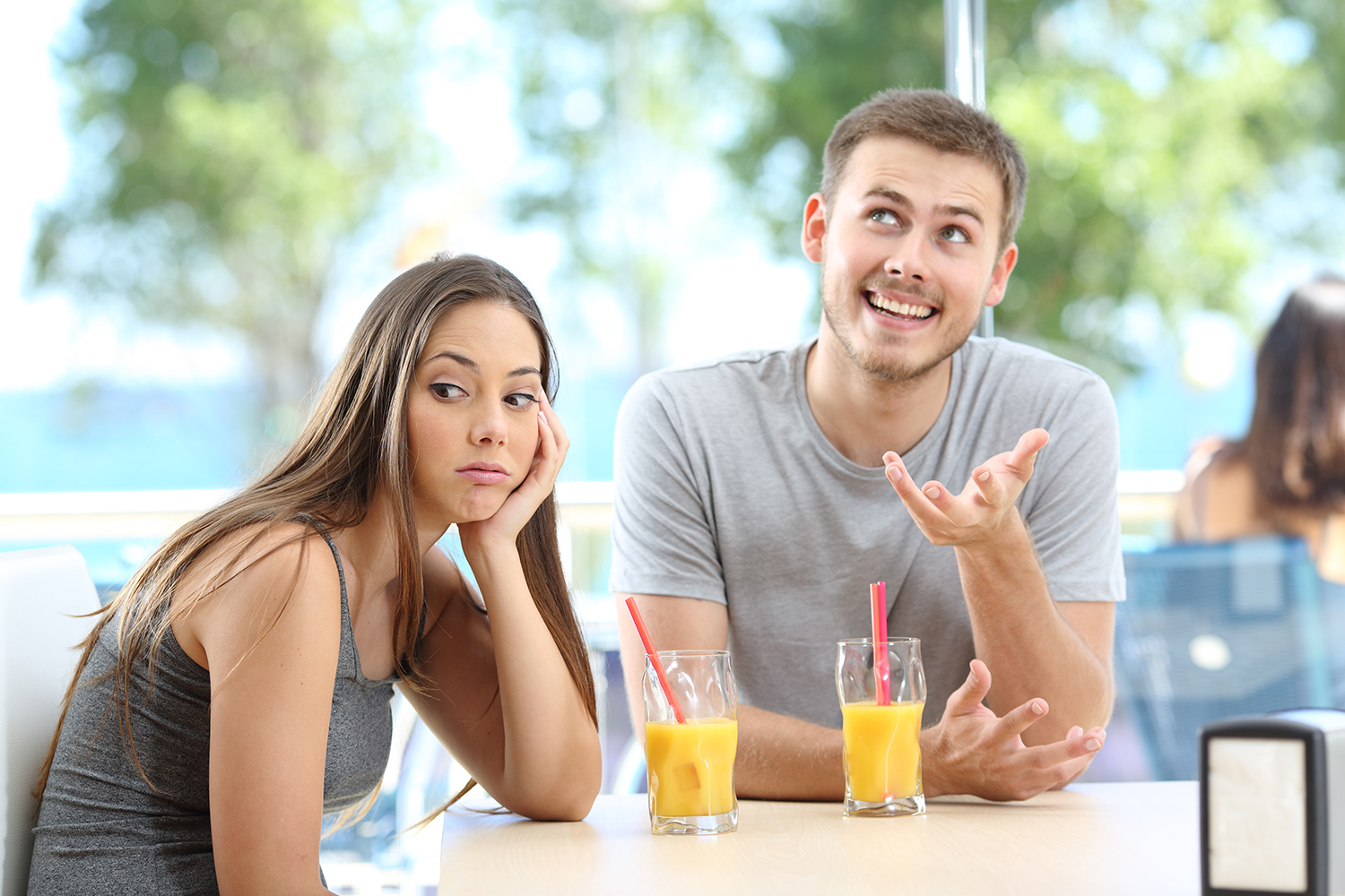 Junges, argumentierendes Paar am Tisch eines Strandrestaurants