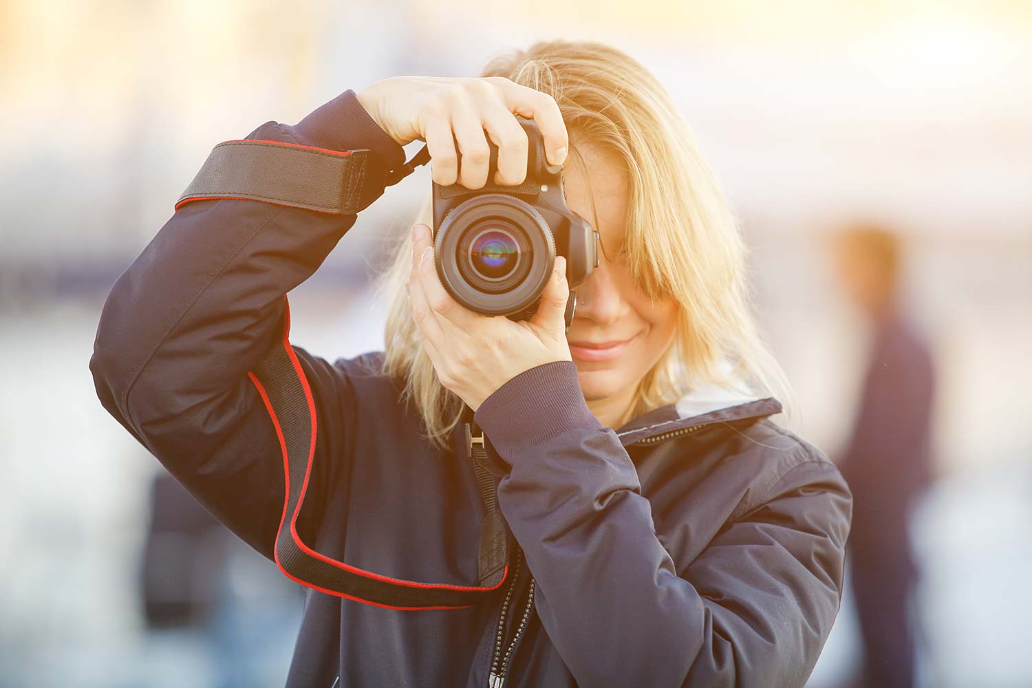 Junge Frau mit Kamera in Outdoor-Kleidung